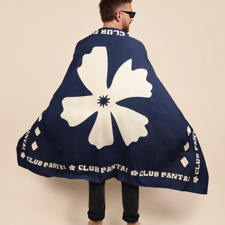 A man wearing a Club Pantai navy-blue sarong with a large white floral design.